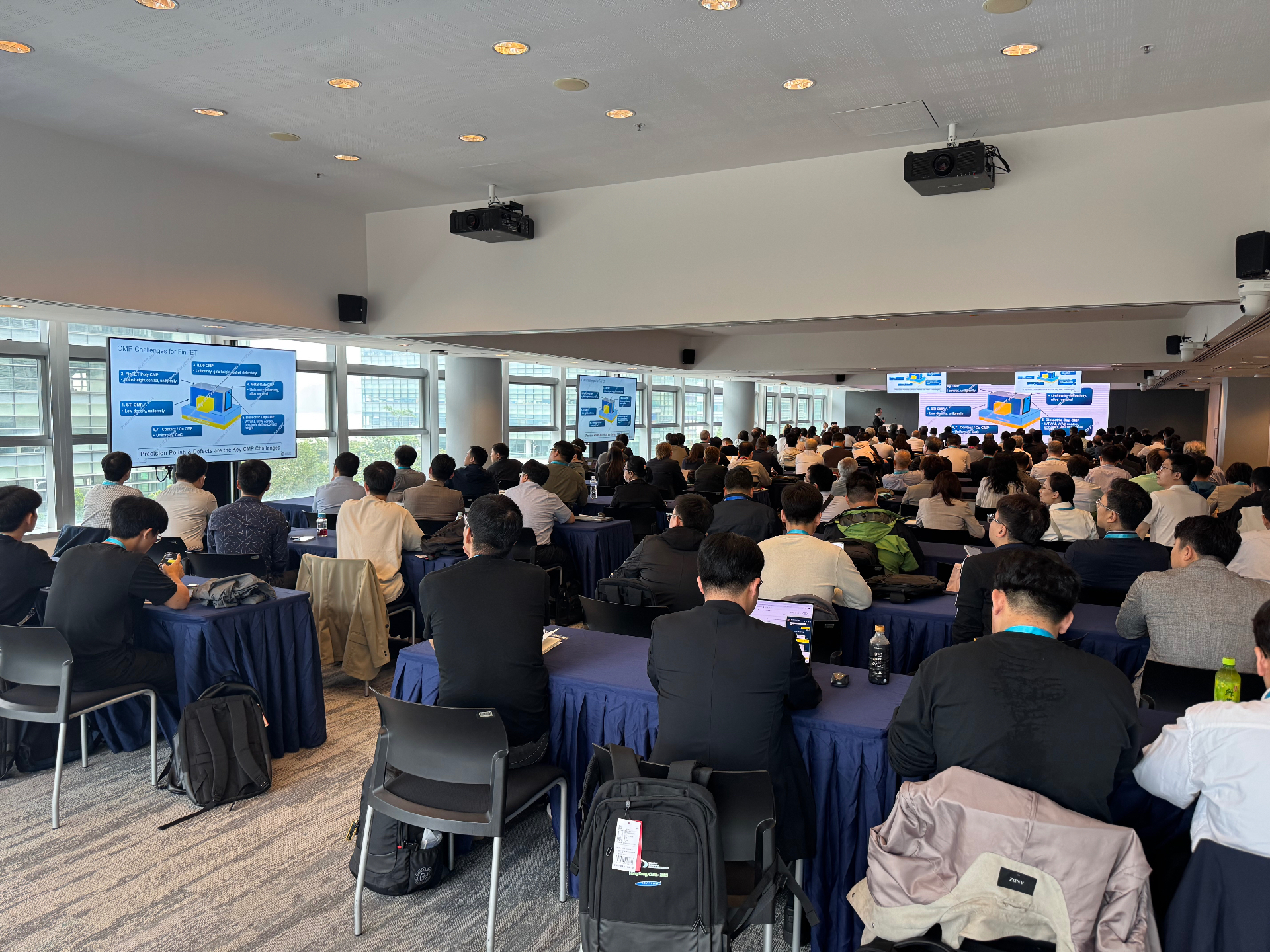 Packed conference hall at ICPT 2025 with attendees viewing CMP technology presentations