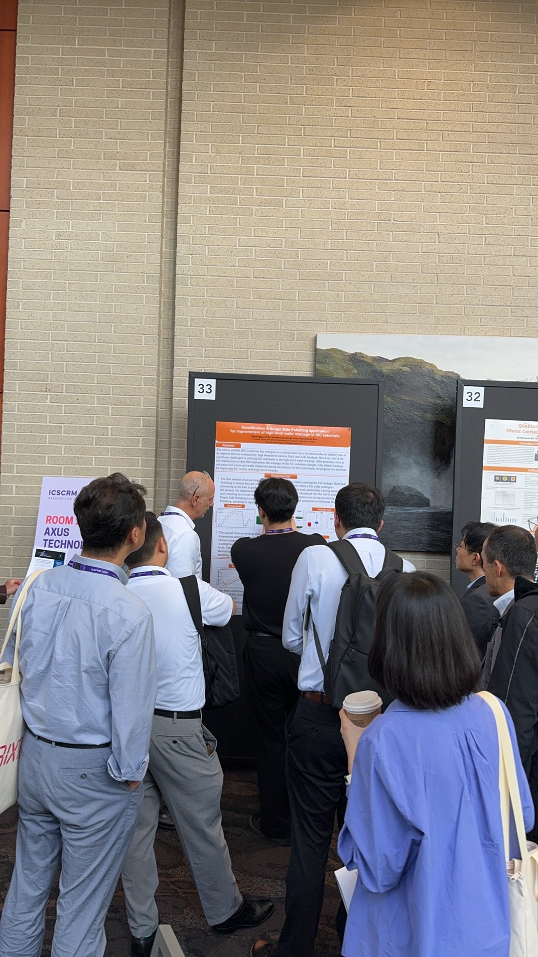 Attendees gathered around a technical poster presentation during ICSCRM 2024 in Raleigh