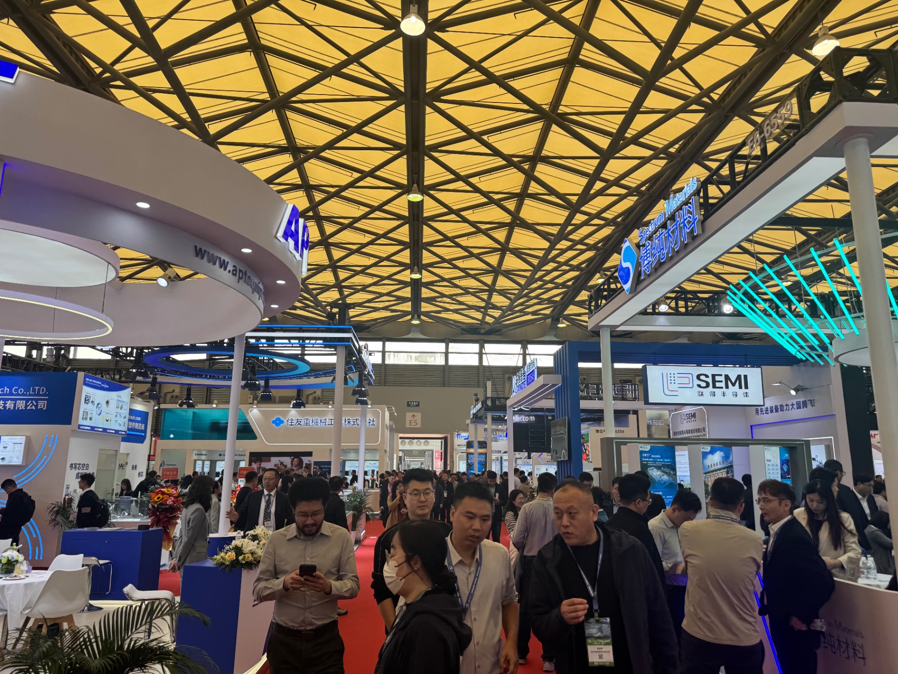 Crowded exhibition aisle with semiconductor materials and equipment booths at SEMICON China