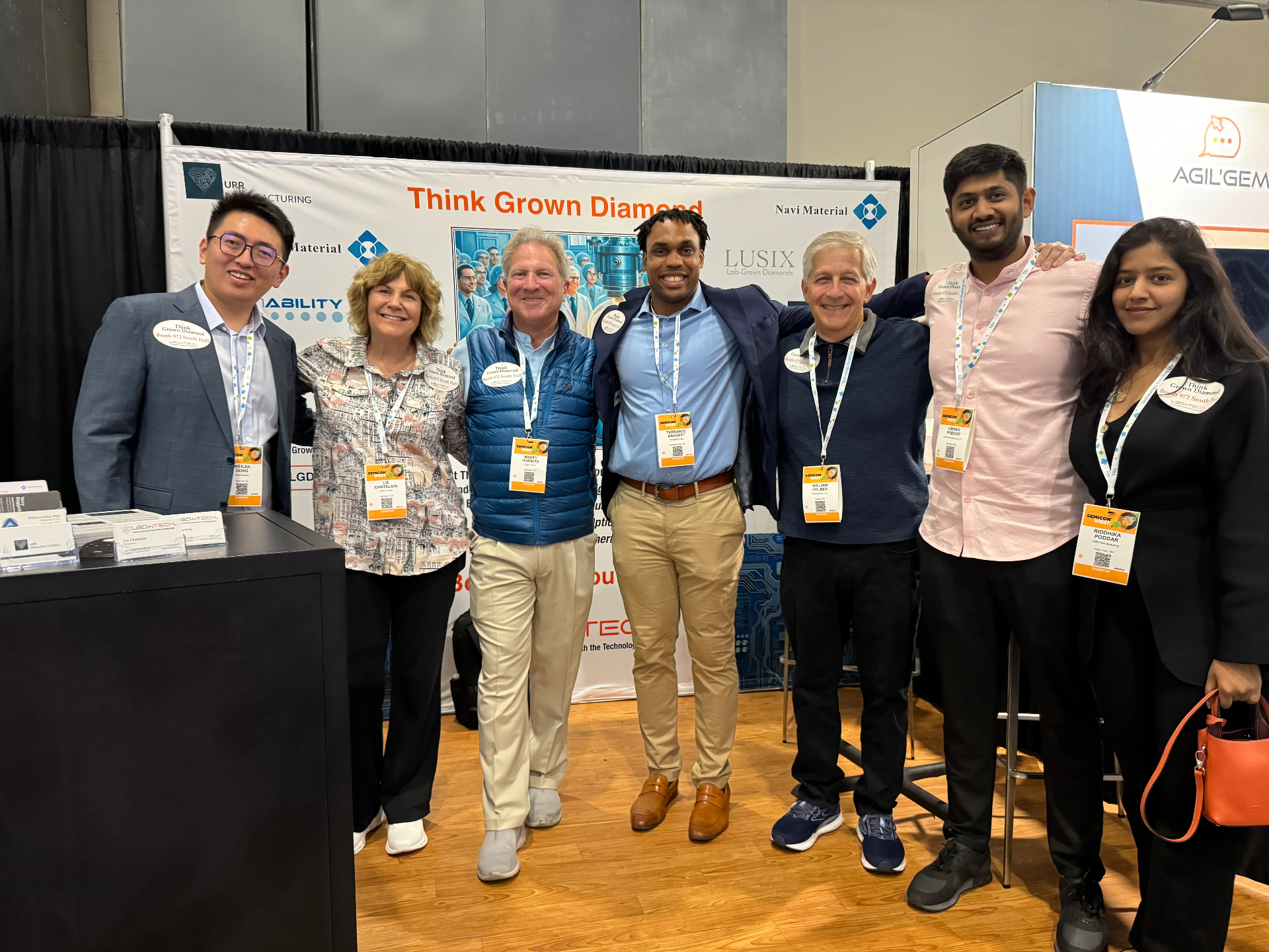Team photo at SEMICON West 2024 in front of Think Grown Diamond and Navi Material booth graphics
