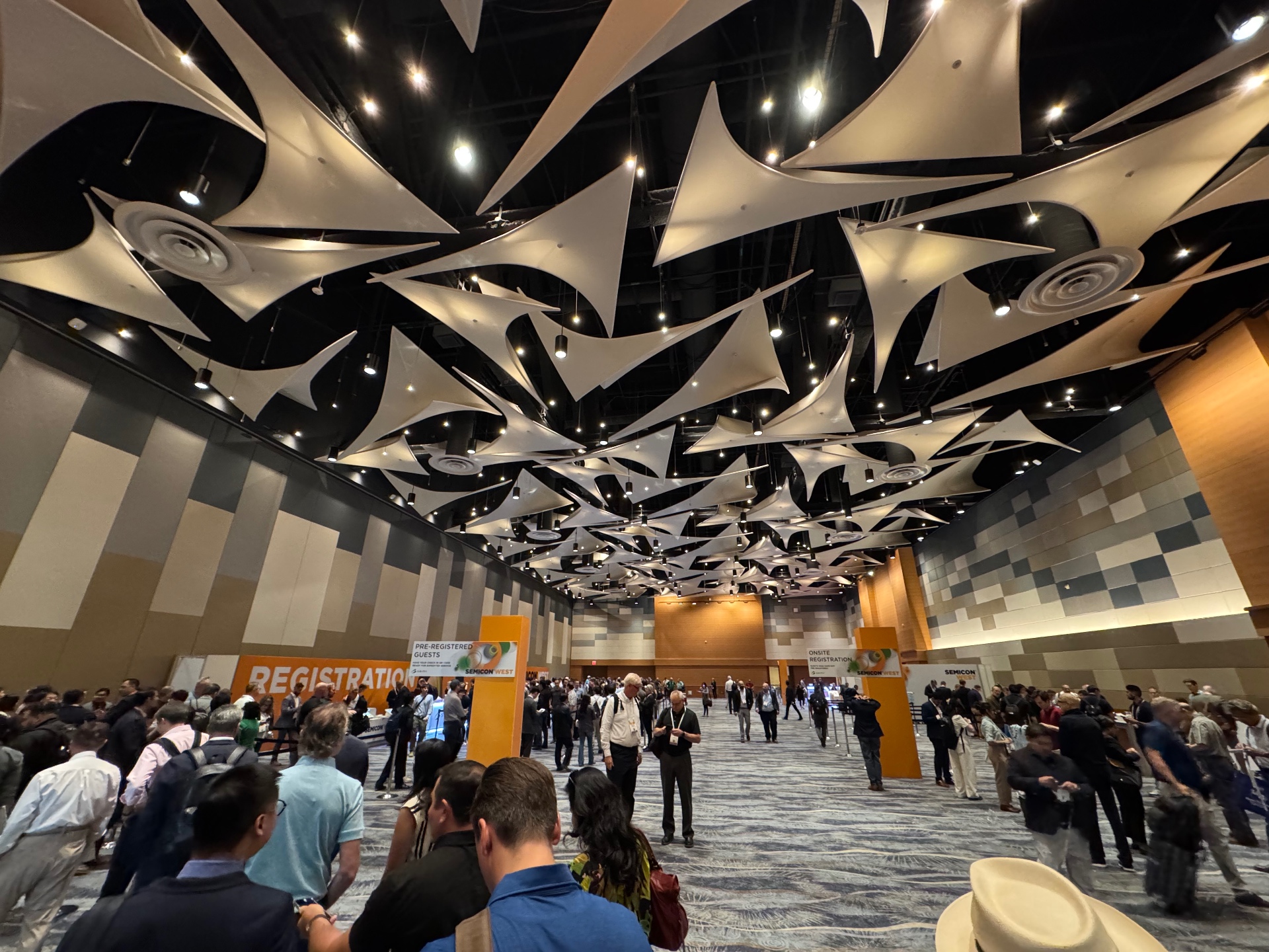 SEMICON West 2025 registration hall in Phoenix with attendees arriving under suspended ceiling panels